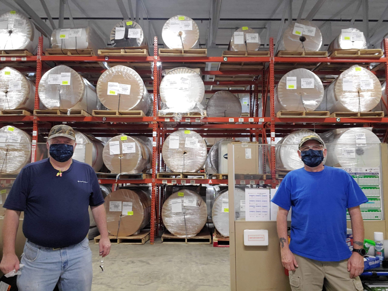 workers in a warehouse wearing masks