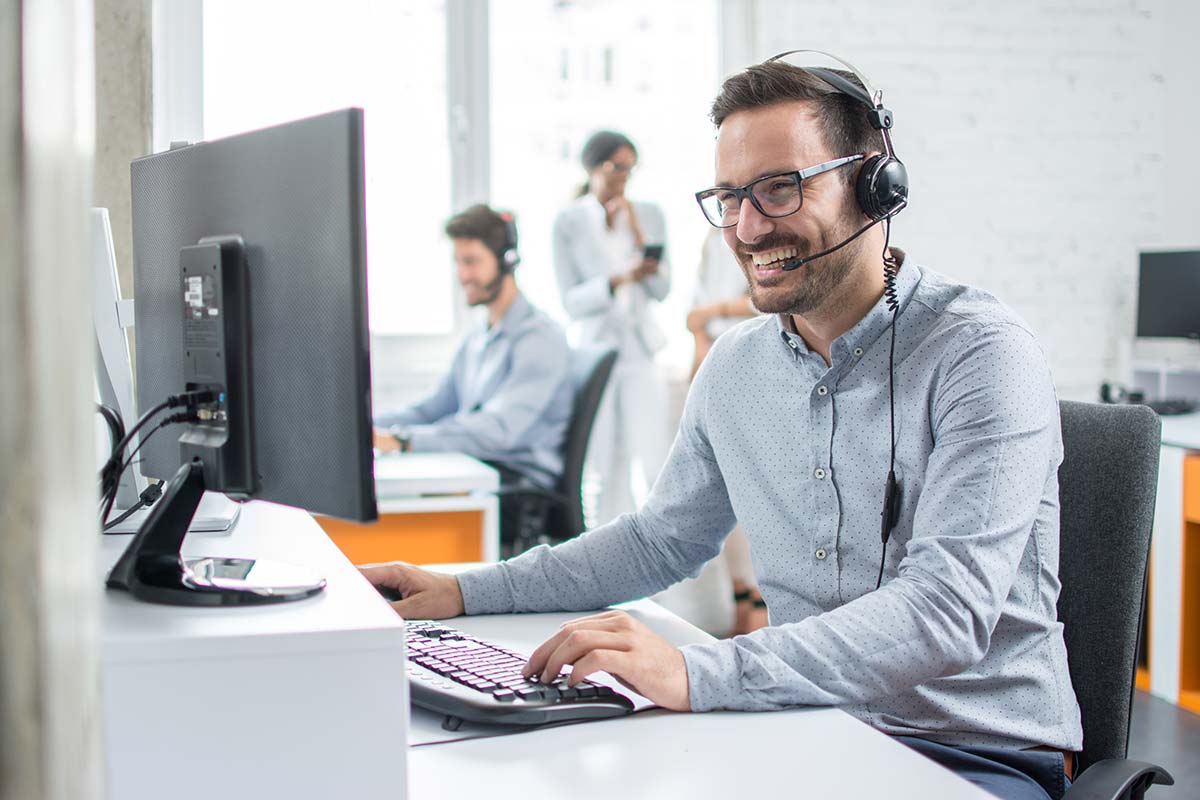 man with headset working on a computer