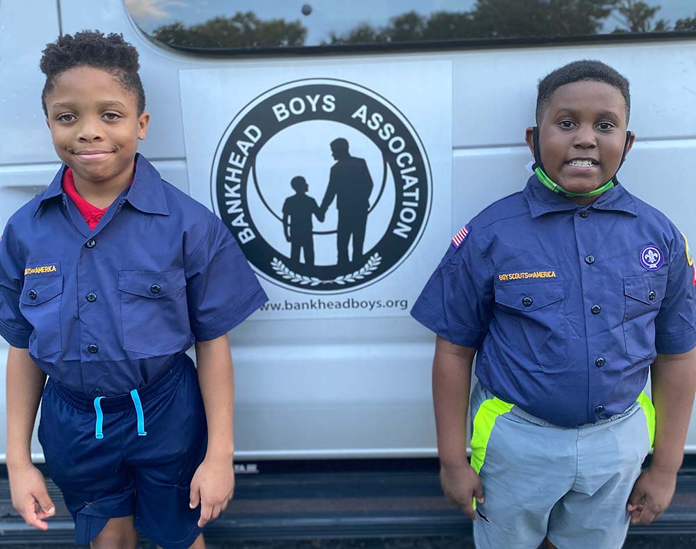 Two boys standing in front of a Bankhead Boys van