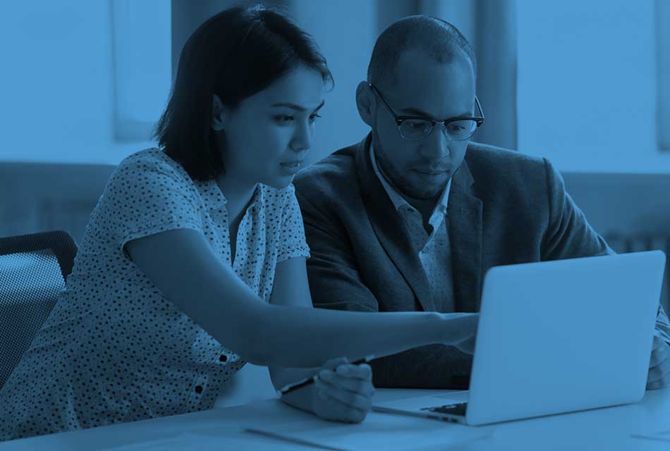 Man and woman looking at laptop while collaborating on a project