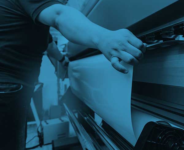 technician feeding paper a dry offset printer